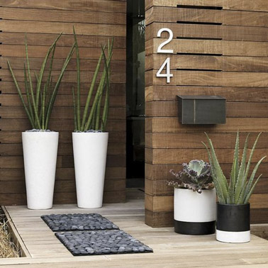We combine wood, small carpet pattern pebbles and cactus for the decor in front of the front door! An ultra-Zen atmosphere that will not fail to put your guests at ease 