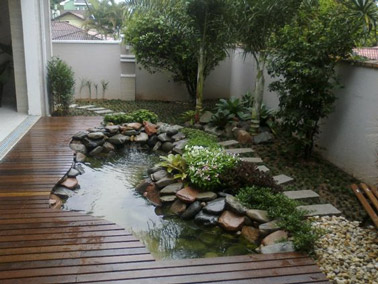 Completely integrated with the wooden terrace and taking place right next to the garden path, this small stone-decorated pool naturally finds its place 